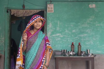 Portrait of smiling indian woman wearing sari covering her face 