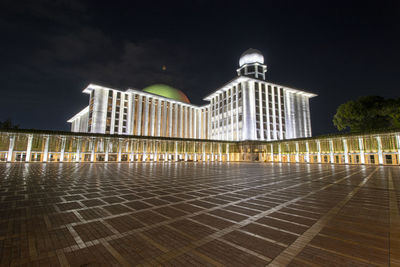 Low angle view of illuminated building against sky at night