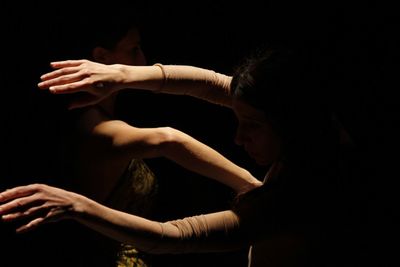 Close-up of women dancing in darkroom