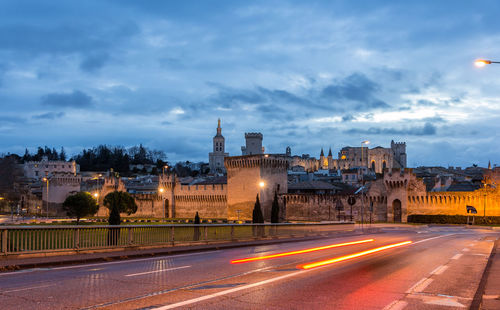 Illuminated city against sky at dusk