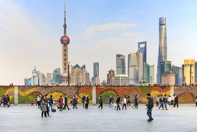 People walking on bund against oriental pearl tower