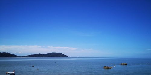 Scenic view of sea against blue sky