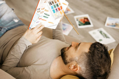 Artist holds a sketchbook in his hands. rest, search for inspiration, artist in the studio