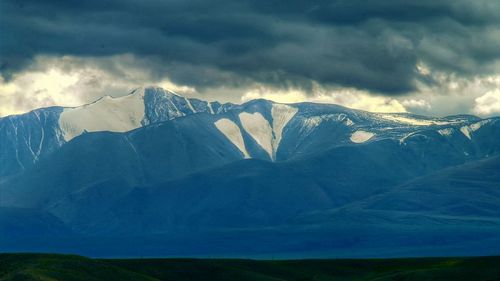 Scenic view of mountains against cloudy sky