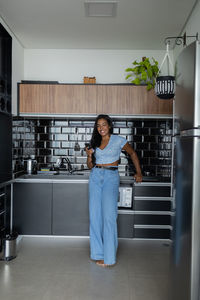 Young black woman working at home with smartphone in the kitchen of apartment. home office.
