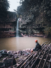 Full length of man sitting on rock