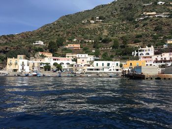 Scenic view of sea by buildings against sky