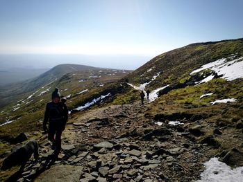 Woman hiking on mountain against sky