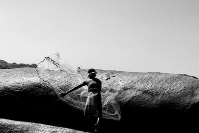 Man holding umbrella against clear sky