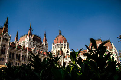 Low angle view of hungarian parliament building against clear blue sky