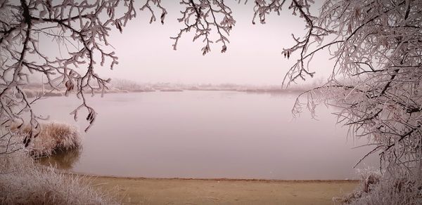 Scenic view of lake against sky during winter