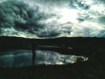 Silhouette landscape against cloudy sky