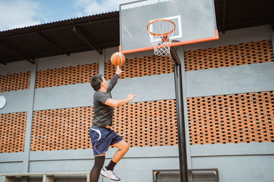 Low section of boy playing with basketball hoop