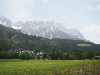 Scenic view of green landscape and mountains against sky