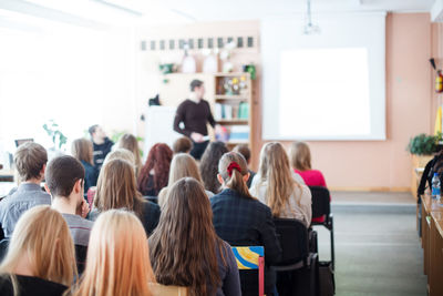 Rear view of students sitting in classroom