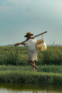 Rear view of woman standing on field