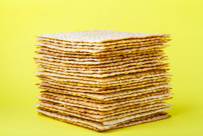 Close-up of stack on table against yellow background