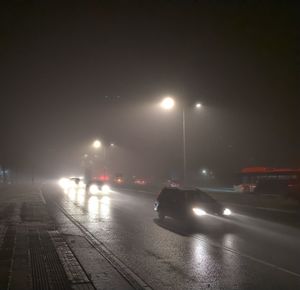 Cars on illuminated street at night