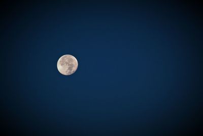 Low angle view of moon against clear blue sky