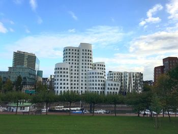 Buildings in park against sky in city