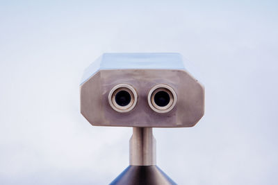 Close-up of coin-operated binoculars against sky
