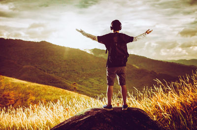 Full length rear view of man with arms outstretched