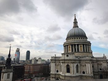 Buildings in city against cloudy sky