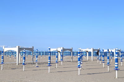 Chairs on beach against clear blue sky