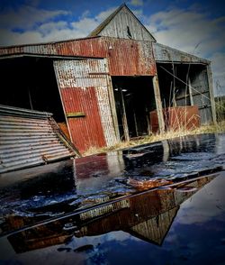 Reflection of built structure in water against sky