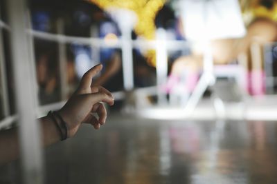 Close-up of human hand gesturing by railing