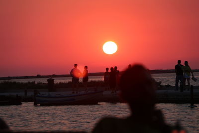 Silhouette people at beach during sunset