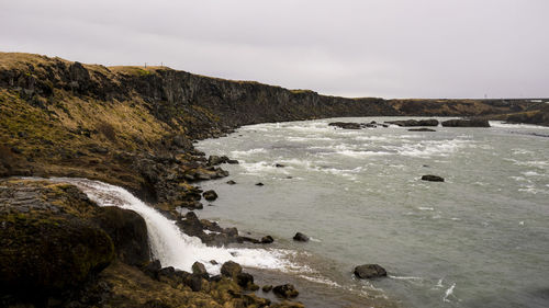 Scenic view of waterfall against sky