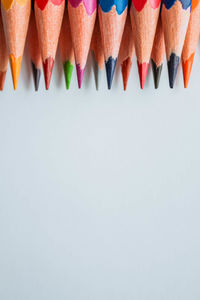 High angle view of multi colored pencils against white background