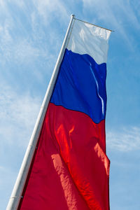 Low angle view of american flag against blue sky