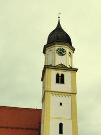 Low angle view of clock tower amidst buildings against sky