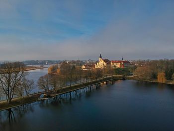 Bridge over river amidst buildings against sky