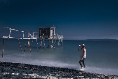 Man standing on beach against clear sky