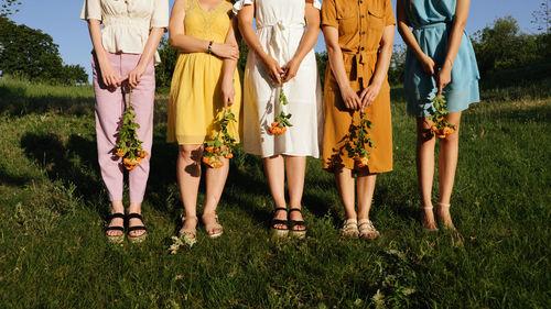 Low section of women standing on plants