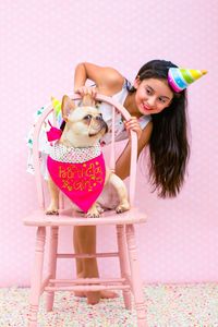 Cute girl looking at dog during birthday party at home