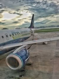 Close-up of airplane on airport runway against sky