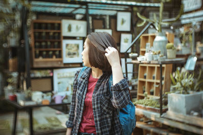 Woman with hand in hair standing outdoors