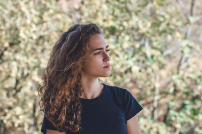 Face of woman dreaming with blue eyes outdoors. curly hair. autumn