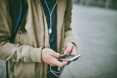 Midsection of man using mobile phone