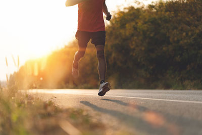 Low section of man running on road