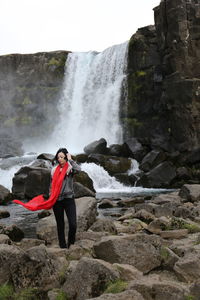 Full length of young woman standing on cliff