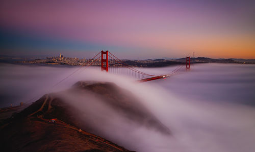 Golden gate bridge over sea against sky during sunset