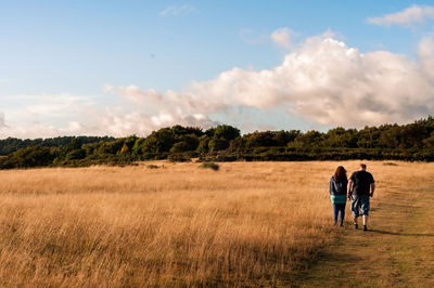 Rear view of man on agricultural field against sky