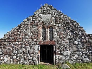 Low angle view of old building against clear blue sky