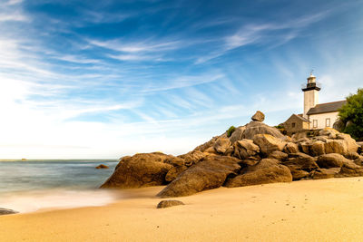 Scenic view of beach with the lighthouse of pontuvel, finistere, brittany, france