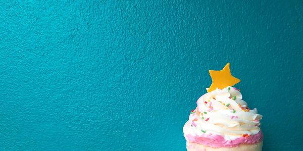 Close-up of ice cream cone against blue background